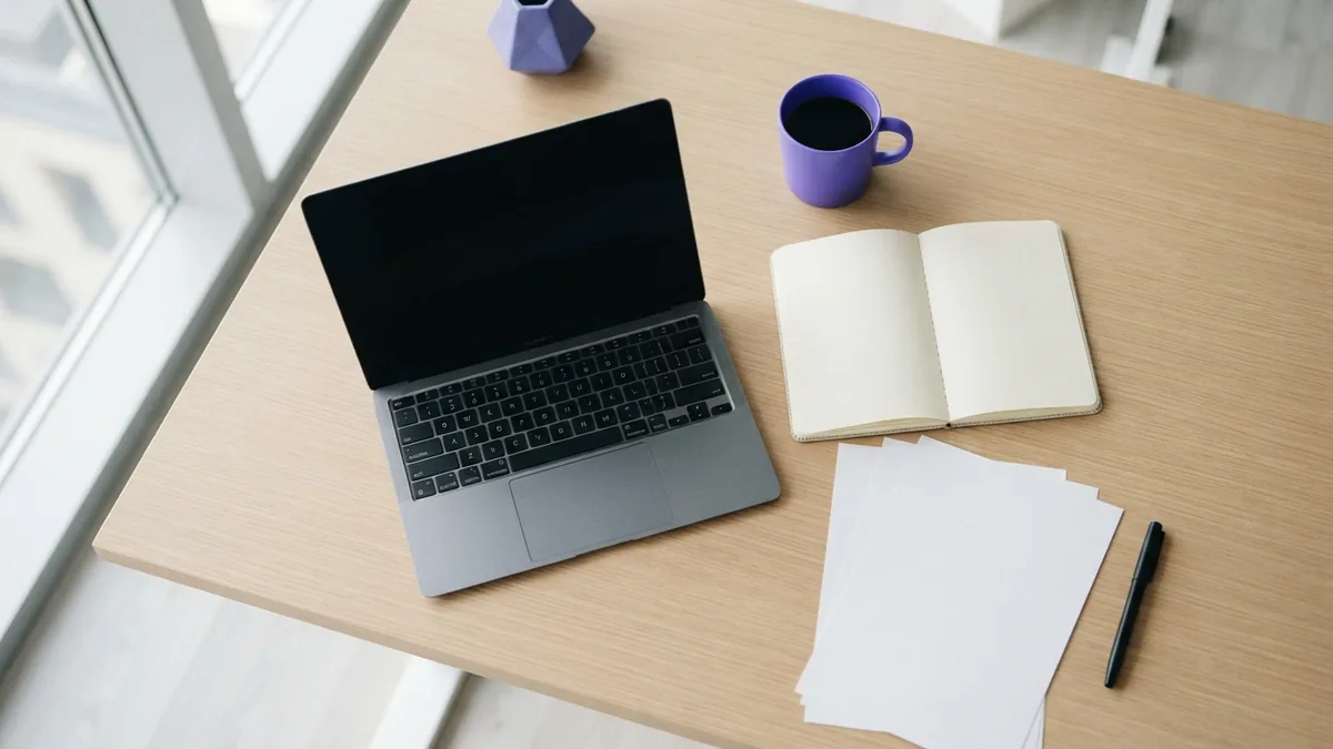 Blank planning papers and a closed laptop arranged on a clean desk