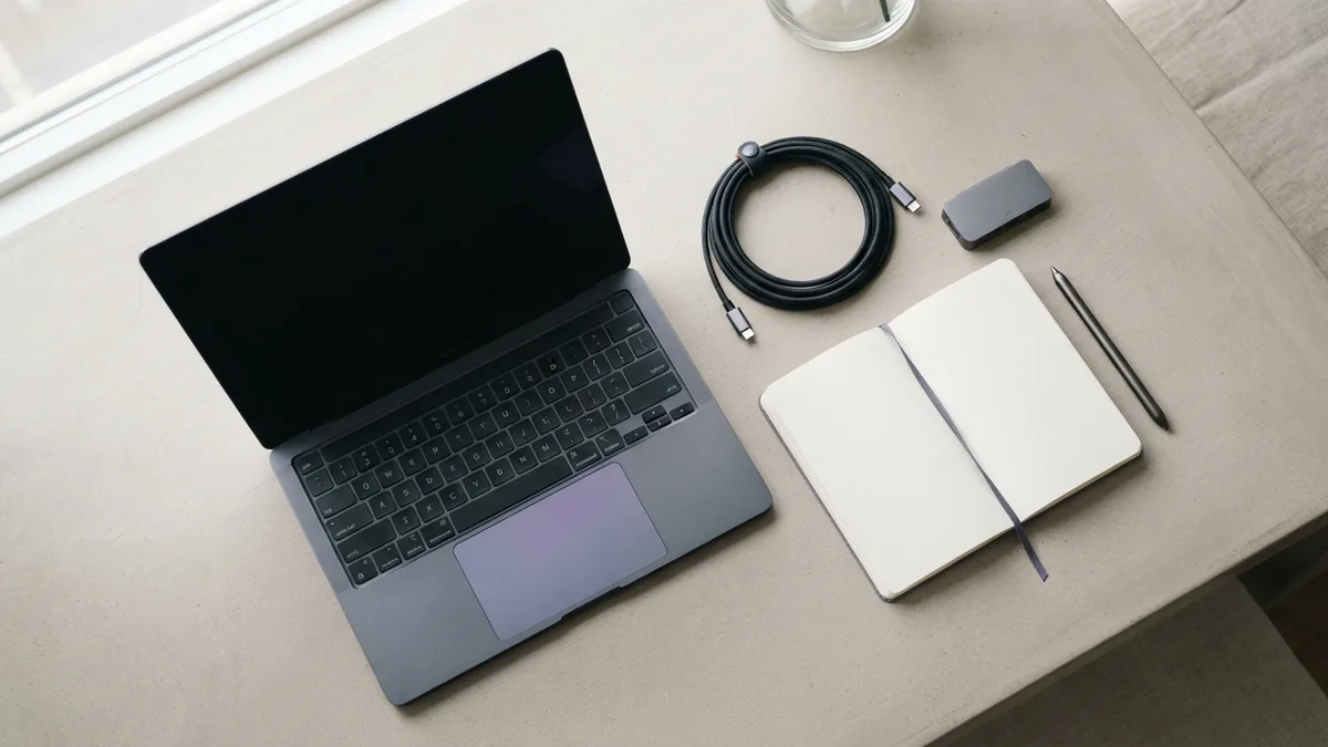 A simple desk for project setup Clean desk with blank laptop, notebook, cable, and hardware for API project setup
